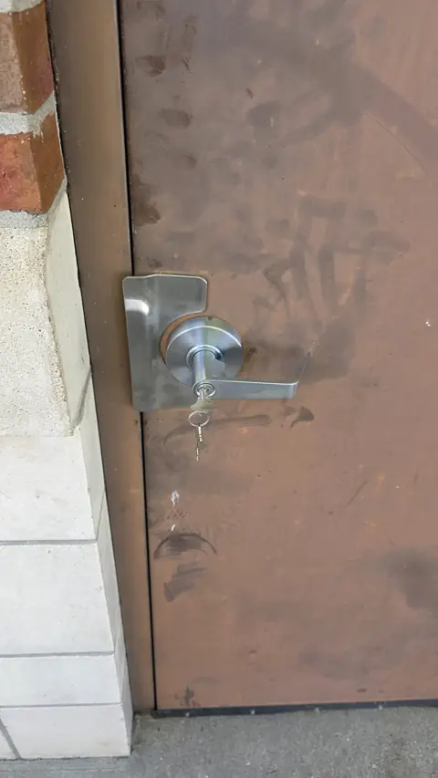 Commercial lever lock installed on a steel back door