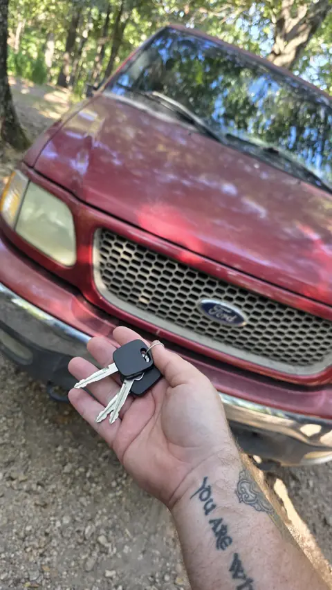 Replacement Ford F-150 keys, a transponder key and a spare, in front of the truck