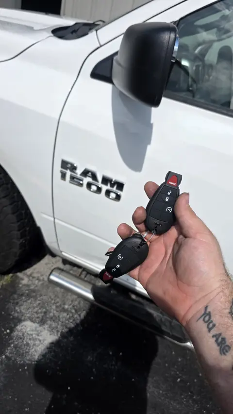 Two new Ram 1500 remote head keys cut and programmed beside the truck